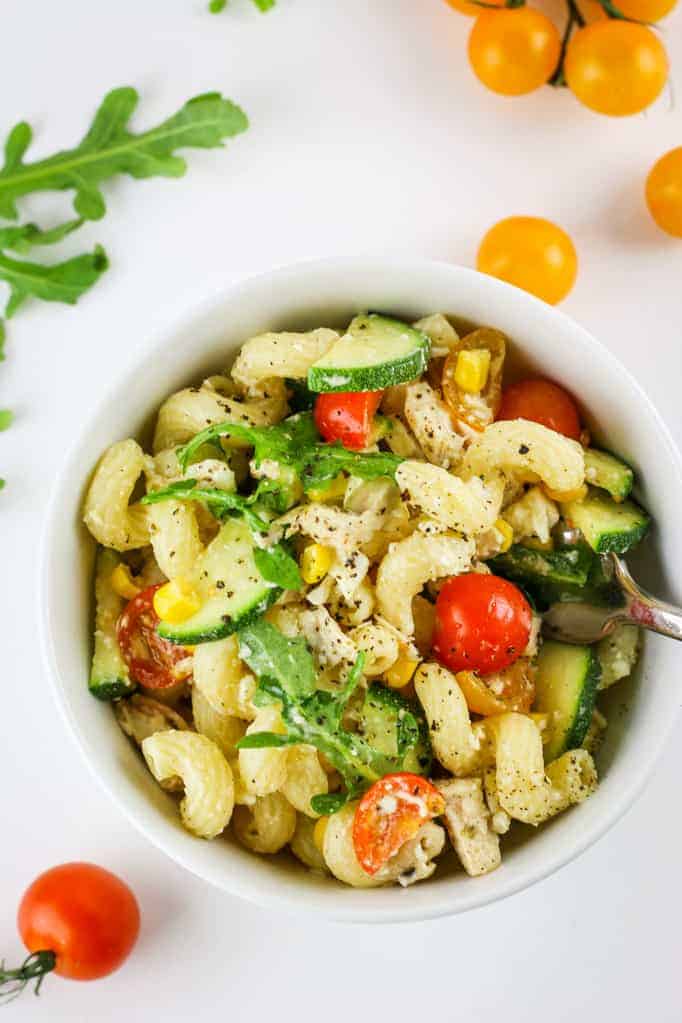 Summer vegetable pasta salad with zucchini, chicken, and tomatoes for cookout.