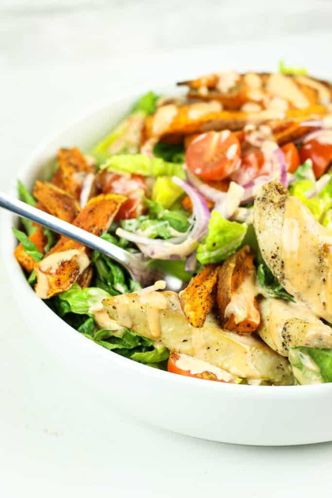 Salad bowls with sweet potatoes, chicken, and chipotle dressing.