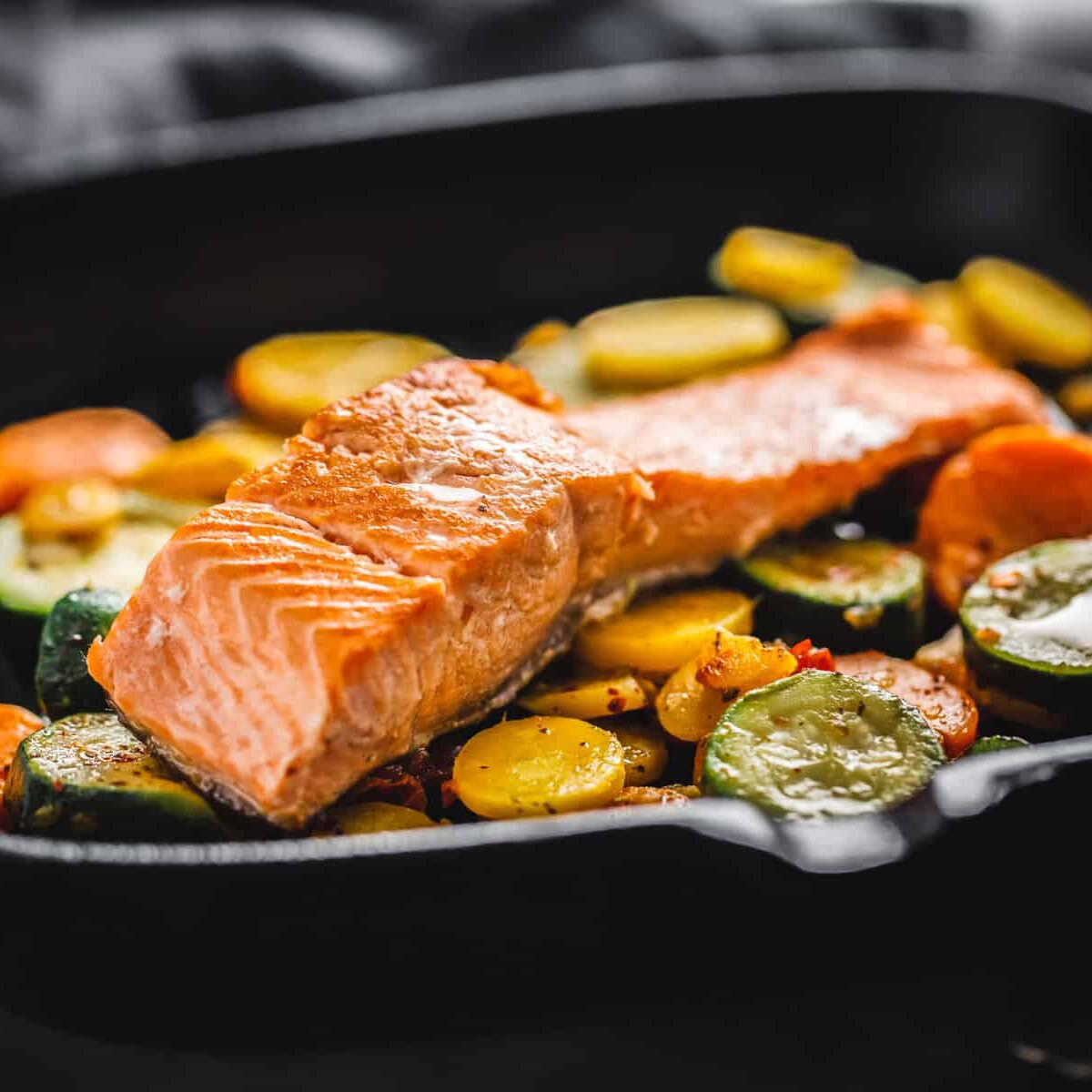 Tasty grilled salmon with vegetables served on grill pan.